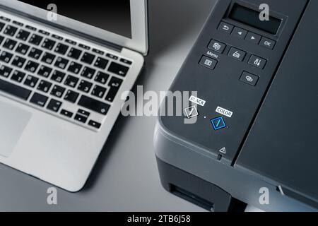 Printer and laptop on grey table in office Stock Photo