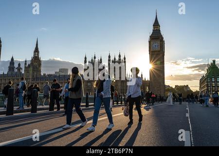 Elegant travel - London at sunset with tourists in front of the Elizabeth Tower, aka Big Ben, walking on Westminster Bridge Stock Photo