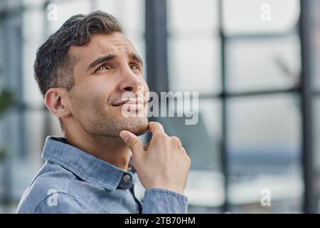 Portrait of cheerful male student enjoying learning in coworking office using laptop computer for research Stock Photo