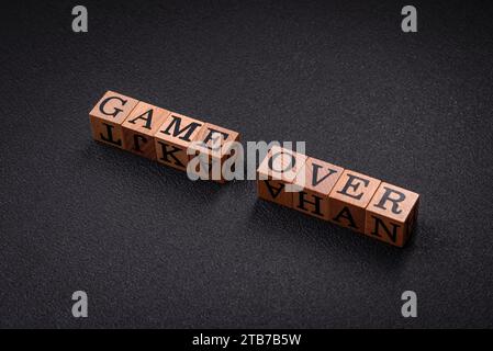 The inscription game over on wooden cubes on a dark concrete background. Can be used as part of your composition Stock Photo