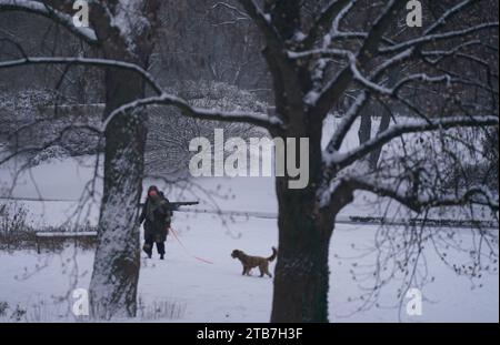 Hamburg, Germany. 05th Dec, 2023. A woman walks through the 'Planten un Blomen' park with a dog. Credit: Marcus Brandt/dpa/Alamy Live News Stock Photo