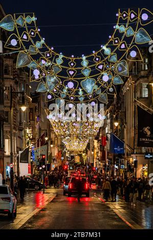 London, UK. 4th Dec, 2023. Despite the cold and wet weather there are plenty of people out shopping and enjoying the Christmas lights on Bond Street early as the Christmas run up continues. Credit: Guy Bell/Alamy Live News Stock Photo