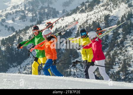 Group of skiers in colorful gear carrying their equipment in the Swiss Alps Stock Photo