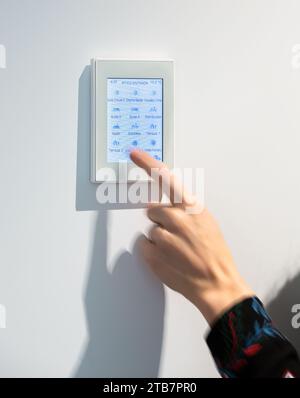 Image showcasing Crop hand of anonymous woman adjusting temperature on thermostat ...