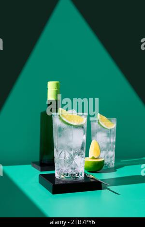 An elegant gin tonic set on a geometric backdrop with vibrant lime slices, casting soft shadows. Stock Photo