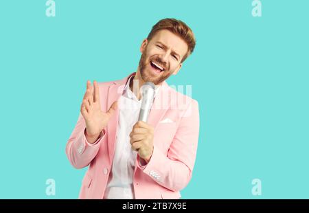Handsome emotional young man singing over microphone and gesturing Stock Photo