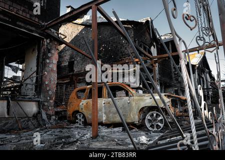 A burnt-out destroyed car near a civilian building. The result of mortar shelling. Russian invasion in Ukraine. Stock Photo