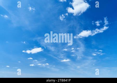 Blue sky with small white clouds on sunny day as bright meteorology background Stock Photo