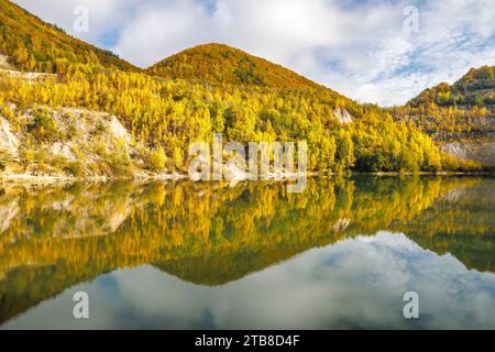Autumn landscape with reflection of colorfull hills in the lake. Flooded quarry near the village Sutovo in Slovakia, Europe. Stock Photo