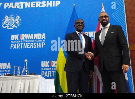 Home Secretary James Cleverly and Rwandan Minister of Foreign Affairs Vincent Biruta shake hands after they signed a new treaty in Kigali, Rwanda. The treaty will address concerns by the Supreme Court, including assurances that Rwanda will not remove anybody transferred under the partnership to another country. Picture date: Tuesday December 5, 2023. Stock Photo