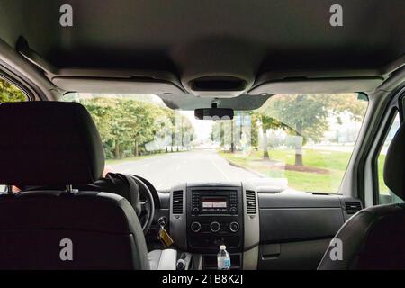 Inside of car with display panel and windscreen on the road in public park Stock Photo