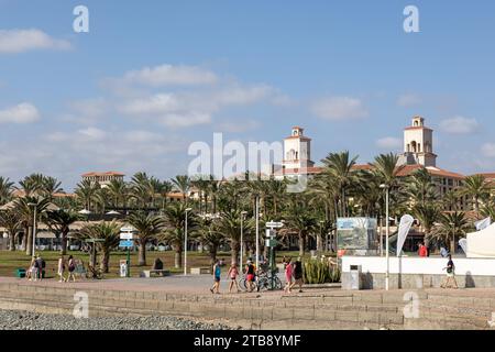 Gran Canaria, Spain - November 23, 2023: Maspalomas  promenade in Gran Canaria, spain,  with tourists enjoying the sunshine Stock Photo