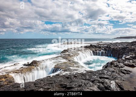 Spectacular natural phenomenon of Bufadero de la Garita where the water goes up and down in the hole like a waterfall with every wave, Gran Canaria is Stock Photo