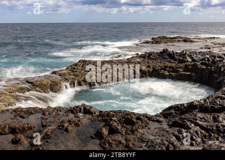 Spectacular natural phenomenon of Bufadero de la Garita where the water goes up and down in the hole like a waterfall with every wave, Gran Canaria is Stock Photo