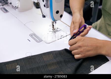 Close up of tailor working on electric sewing machine Stock Photo