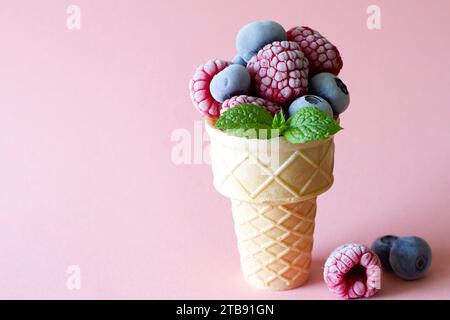Frozen summer fruits with mint leaf in waffle on pink background, summer ice cream concept Stock Photo