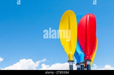 Closeup of colorful rowing paddle blades on blue sky background Stock Photo