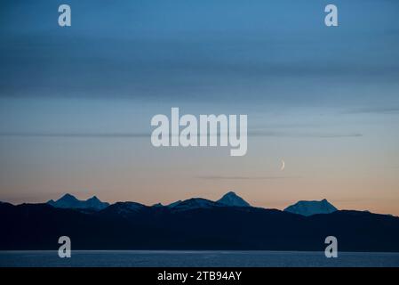 Crescent moon above Glacier Bay at dusk, Inside Passage, Alaska, USA; Alaska, United States of America Stock Photo