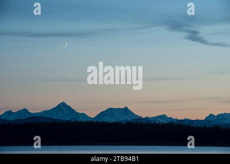 Crescent moon above Glacier Bay at dusk, Inside Passage, Alaska, USA; Alaska, United States of America Stock Photo