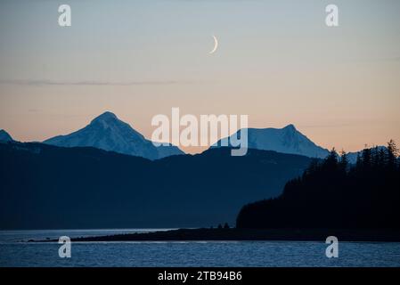 Crescent moon above Glacier Bay at dusk, Inside Passage, Alaska, USA; Alaska, United States of America Stock Photo