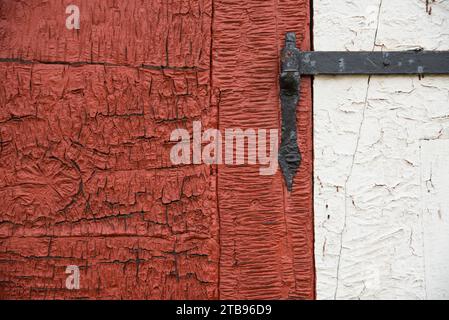 Old wrought iron hinge on a weathered door and frame; Sisimiut, Greenland Stock Photo