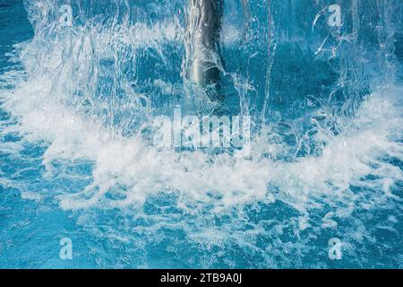 Closeup of a Waterfall mushroom in a swimming pool creating a large splash for fun in a hotel Stock Photo