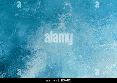 Swirling blue pool water with light reflections and gentle ripples at a spa hotel Stock Photo