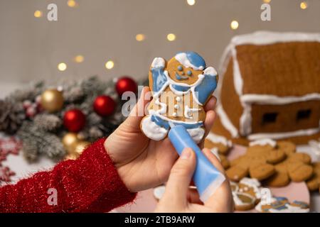 Decorating Christmas gingerbread with sugar multicolored icing. Stock Photo