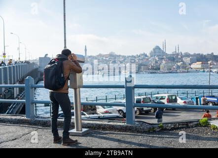 Young man looking through binoculars at the blue mosque in Istanbul Stock Photo
