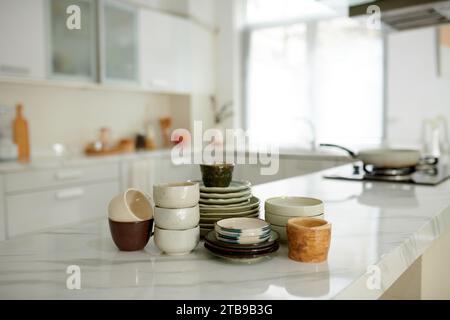 Ceramic bowls, plates and cups on kitchen counter Stock Photo