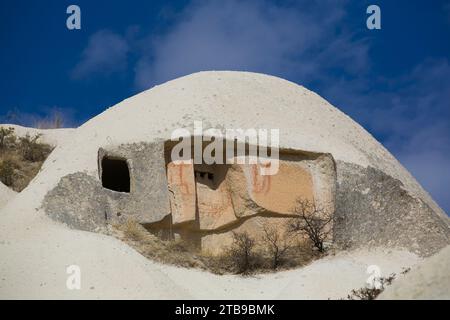 Close-up of domed, Cave House against a bright blue sky in the town of Goreme in Pigeon Valley, Cappadocia Region; Nevsehir Province, Turkey Stock Photo