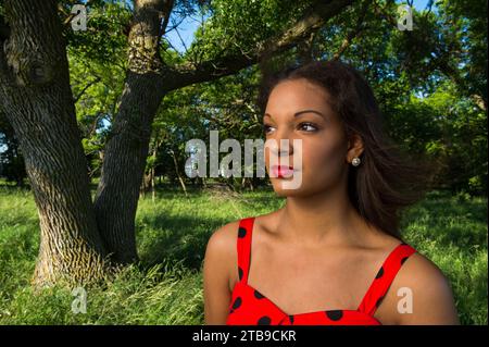 Close-up outdoor portrait on a beautiful young woman in a red polka dot dress; Bennet, Nebraska, United States of America Stock Photo