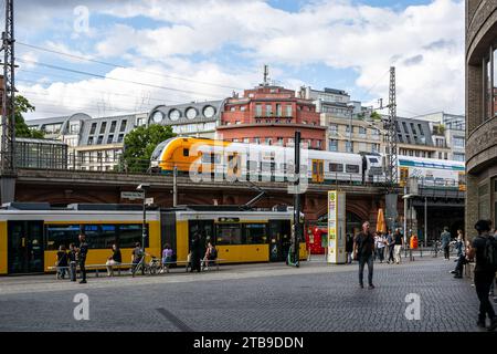 Berlin, Germany, July 20: Cityscape with a yellow tram and high-speed train on a railway overpass in one of the areas in Berlin on July 20, 2023. Stock Photo