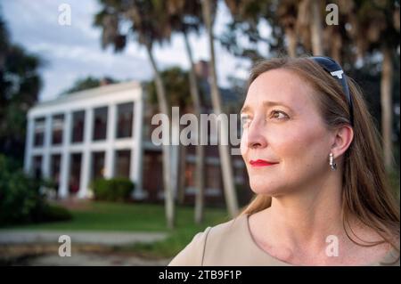 Outdoor portrait of a mature woman with a historic house in the background along Florida's Gulf Coast; Osprey, Florida, United States of America Stock Photo
