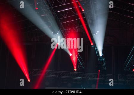 Stage lights during a concert. Light cannons project colored beams of light in different directions Stock Photo