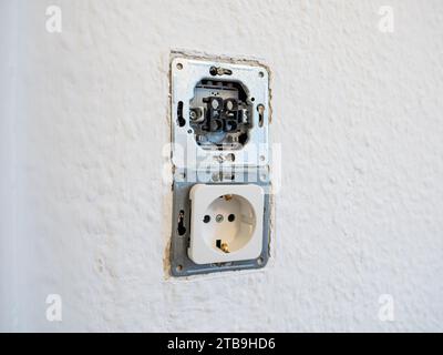Open wall socket close up during the installation of power outlets in an apartment. Renovation of the domestic electrical system at home. Stock Photo