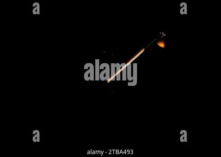 Lit and falling match on a black background. Stock Photo