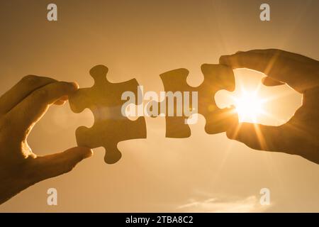 Hand connecting puzzle pieces together, problem solving concept Stock Photo