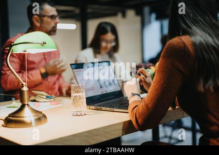 Businesspeople collaborating at night on project development, analyzing reports, and discussing strategies for business growth. Stock Photo