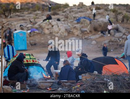 Jacumba Hot Springs, California, USA. 3rd Dec, 2023. Asylum seeking migrants from China try to stay warm next to a fire in an open-air holding area next to the U.S.-Mexico border near the small, desert San Diego County community of Jacumba Hot Springs. The U.S. is seeing a big increase in Chinese immigrants arriving using a relatively new and perilous route through Panama's Darien Gap jungle, thanks in part to social media posts and videos providing step-by-step guidance. (Credit Image: © K.C. Alfred/ZUMA Press Wire) EDITORIAL USAGE ONLY! Not for Commercial USAGE! Stock Photo