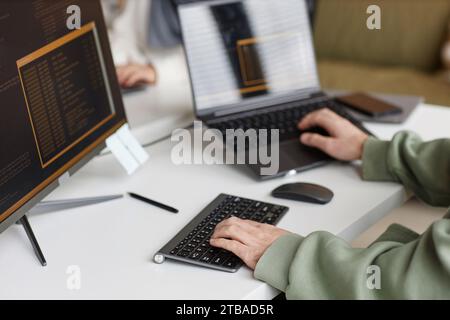 Closeup of male hands typing at computer keyboard with unrecognizable software programmer writing code, copy space Stock Photo