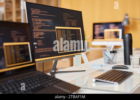 Close up background image of computer screen with colored code lines at workplace in IT development office, copy space Stock Photo