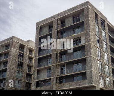 A gloomy gray building. Unfinished brutalist house. Concept of crisis in construction. Gray architecture. Cloudy autumn weather. Concrete house for pe Stock Photo