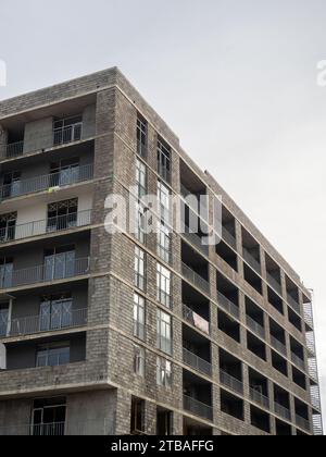 A gloomy gray building. Unfinished brutalist house. Concept of crisis in construction. Gray architecture. Cloudy autumn weather. Concrete house for pe Stock Photo