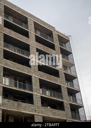 A gloomy gray building. Unfinished brutalist house. Concept of crisis in construction. Gray architecture. Cloudy autumn weather. Concrete house for pe Stock Photo