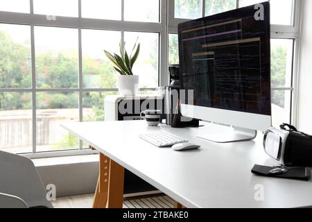 Computer monitor with programming code at workplace in office Stock Photo