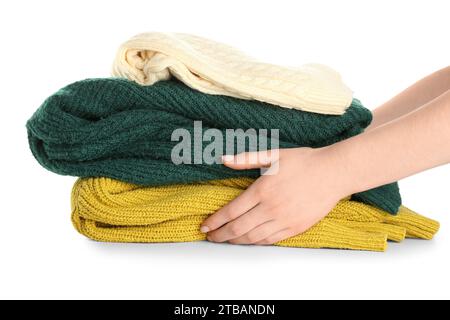 Female hands with stack of different stylish sweaters on white background Stock Photo