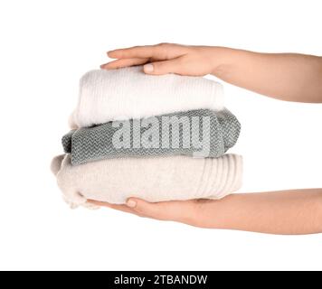 Female hands with stack of different stylish sweaters on white background Stock Photo