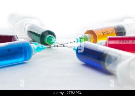 Syringes filled with colorful liquids are neatly arranged on an isolated background Stock Photo