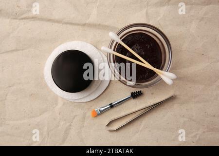 Flat lay composition with eyebrow henna and tools on crumpled paper Stock Photo